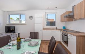 cocina con mesa y botella de vino en 3 Bedroom Amazing Apartment In Malinska, en Malinska