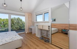 Un dormitorio con una cama, un escritorio y ventanas. en 3 Bedroom Amazing Apartment In Malinska, en Malinska