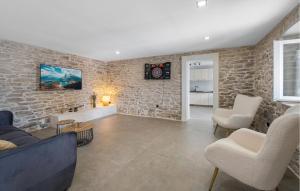 a living room with a stone wall at Lovely Home In Plastovo With Sauna in Plastovo
