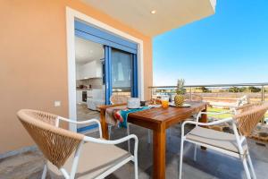 Un comedor con una mesa y dos sillas. en Cindy Luxury Villas Crete BLUE, en Stavros