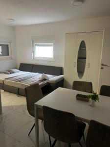 a room with a bed and a table and chairs at Apartments Pool Villa Maria, Novalja in Novalja +19 photos