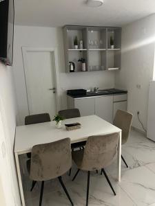 a kitchen with a white table and chairs at Apartments Pool Villa Maria, Novalja in Novalja