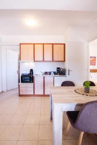 a kitchen with a wooden table and a dining room at Romanos Beach Villas in Romanu