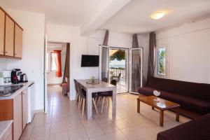 a kitchen and a living room with a table at Romanos Beach Villas in Romanu +37 photos