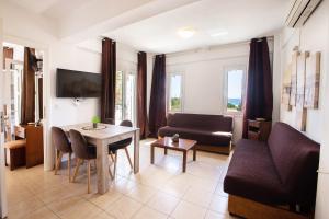 a living room with a couch and a table at Romanos Beach Villas in Romanu