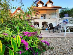 a house with a bench and flowers in front of it at Holiday home in Balatongyörök 43114 in Balatongyörök