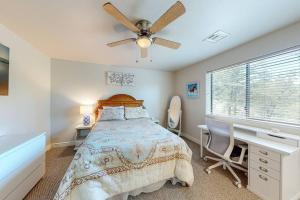 a bedroom with a bed and a desk and a ceiling fan at Elegant Cabin Among the Pines-Views, Near Downtown in Prescott