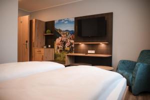 a hotel room with two beds and a tv at Gasthaus Stroh in Buchholz