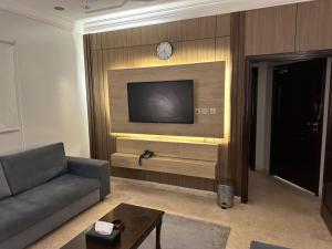 a living room with a couch and a tv on a wall at فخامة المدينة in Medina
