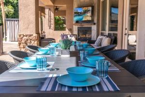 a long table with blue bowls and plates on it at Casa Serenity - Luxury Living w Pool & Jacuzzi in Indio