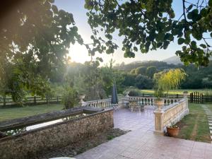 a patio with a fence and a table and umbrella at Casale delle ginestre. in Castel Madama