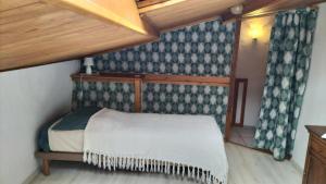a small bed in a room with a wooden ceiling at Villa charmante à Sisteron avec piscine privée in Sisteron +20 photos