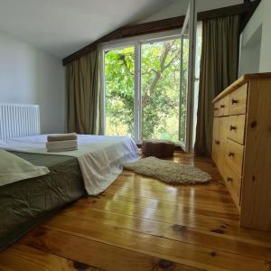 a bedroom with a bed and a large window at Mansarda boema, gradina de basm in Bucharest