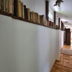 a row of books on a shelf on a wall at Mansarda boema, gradina de basm in Bucharest
