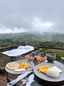 two plates of food on a table with mountains in the background at Entre Nubes Eco Hotel in El Queremal