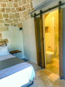 a bedroom with a bed and a bathroom with a toilet at Trullideserio in San Michele Salentino