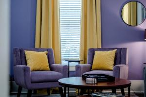 ein Wohnzimmer mit zwei Stühlen und einem Tisch in der Unterkunft Vineyard Cottage-Pet Friendly & Walk to Oaklawn! in Hot Springs + 53 Fotos