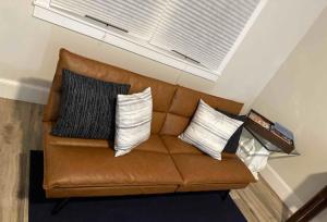 a brown leather couch with four pillows on it at Delightful 3-bedroom house in Bradenton #2 of 2 in Bradenton