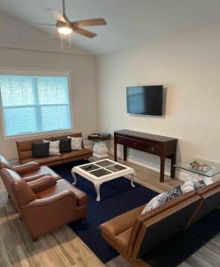 a living room with leather furniture and a piano at Delightful 3-bedroom house in Bradenton #2 of 2 in Bradenton