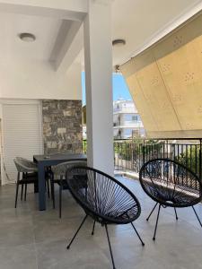 a patio with two chairs and a table and a balcony at Anafis Exclusive in Athens