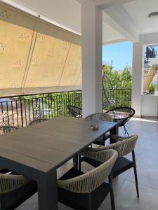 a table and chairs in a room with a balcony at Anafis Exclusive in Athens