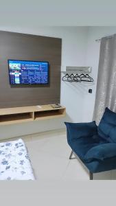 a living room with a tv and a blue chair at Hotel CNP Brasil in Campo Novo do Parecis +23 photos