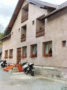 two motorcycles parked in front of a building at Casa Vânătorilor in Arieşeni