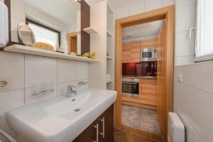 a white bathroom with a sink and a kitchen at Gastein Living in Bad Hofgastein +7 photos