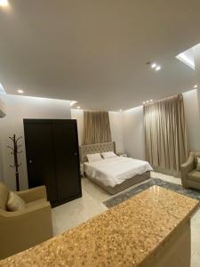 ein Schlafzimmer mit einem Bett, einer Couch und einem Tisch in der Unterkunft ملفى أبها in ‘Aryam