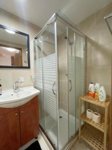 a bathroom with a glass shower and a sink at Eilat Beach House in Eilat