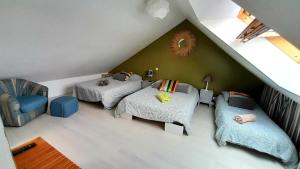 a attic room with three beds and a couch at Home Sweet Home in Le Mans