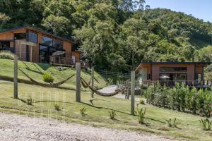 una casa con una hamaca delante de ella en Cabana do Lago - Villas Mornas Natureza e Jacuzzi, en Aguas Mornas