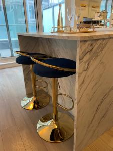 un bancone con due sgabelli da bar blu in una cucina di Yorkville Terrace a Toronto