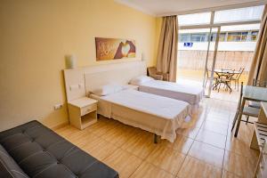 pokój hotelowy z dwoma łóżkami i balkonem w obiekcie Increíble ático en Playa Martiánez w Puerto de la Cruz