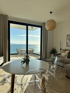 a living room with a table and chairs and a view of the ocean at Veronica Apartment in Sarandë +20 photos