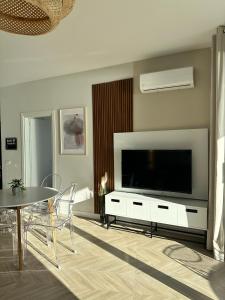 a living room with a large television and a table at Veronica Apartment in Sarandë
