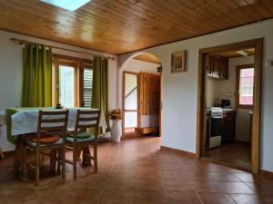a kitchen and dining room with a table and chairs at Andrea Vendégház in Izvoru Mureşului