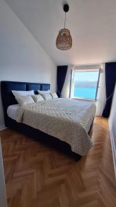 a bedroom with a bed with a large window at Villa M in Neum