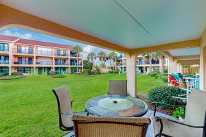 un patio con tavolo e sedie e un edificio di Patio Condo in Oceanfront Community w/ Pool – Walk to Beach a St. Augustine