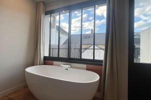 a white bath tub in a room with a window at Le Loft des Lumières in Château-Gontier +24 photos