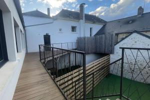 a balcony with a fence and a white house at Le Loft des Lumières in Château-Gontier