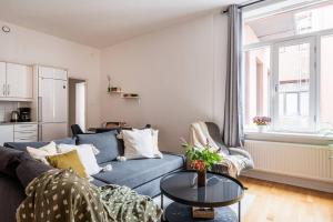 a living room with a blue couch and a table at Large Central Gothenburg 2bd Apt in Gothenburg