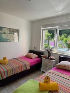 sypialnia z dwoma łóżkami i dwoma oknami w obiekcie Comfortable apartment near Opatija w mieście Matulji