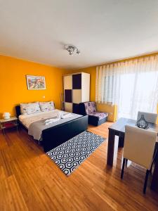 a bedroom with a bed and a couch and a table at Apartments Kristal in Kaštela