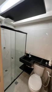 a bathroom with a toilet and a shower and a sink at Suíte Gold Cinema 303 in Santo Antônio do Descoberto