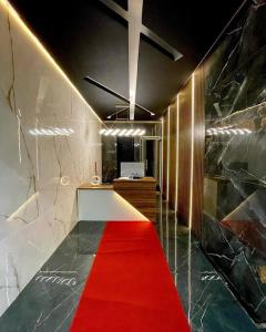 a room with a red carpet and a desk with a red carpet at Suíte Gold Cinema 303 in Santo Antônio do Descoberto