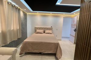 a bedroom with a large bed in a room at Suíte Gold Cinema 303 in Santo Antônio do Descoberto