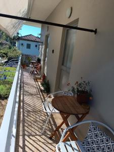 a patio with a table and chairs on a balcony at GIOTAS APARTMENTS - STUDIOS in Argalasti