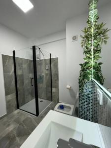 La salle de bains est pourvue d'une douche et de toilettes avec des plantes. dans l'établissement Apartament Denisa Baile Felix, à Cordău 9 autres photos