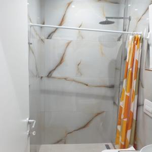 a bathroom with a shower with white marble at Rooms by George in Dhërmi
